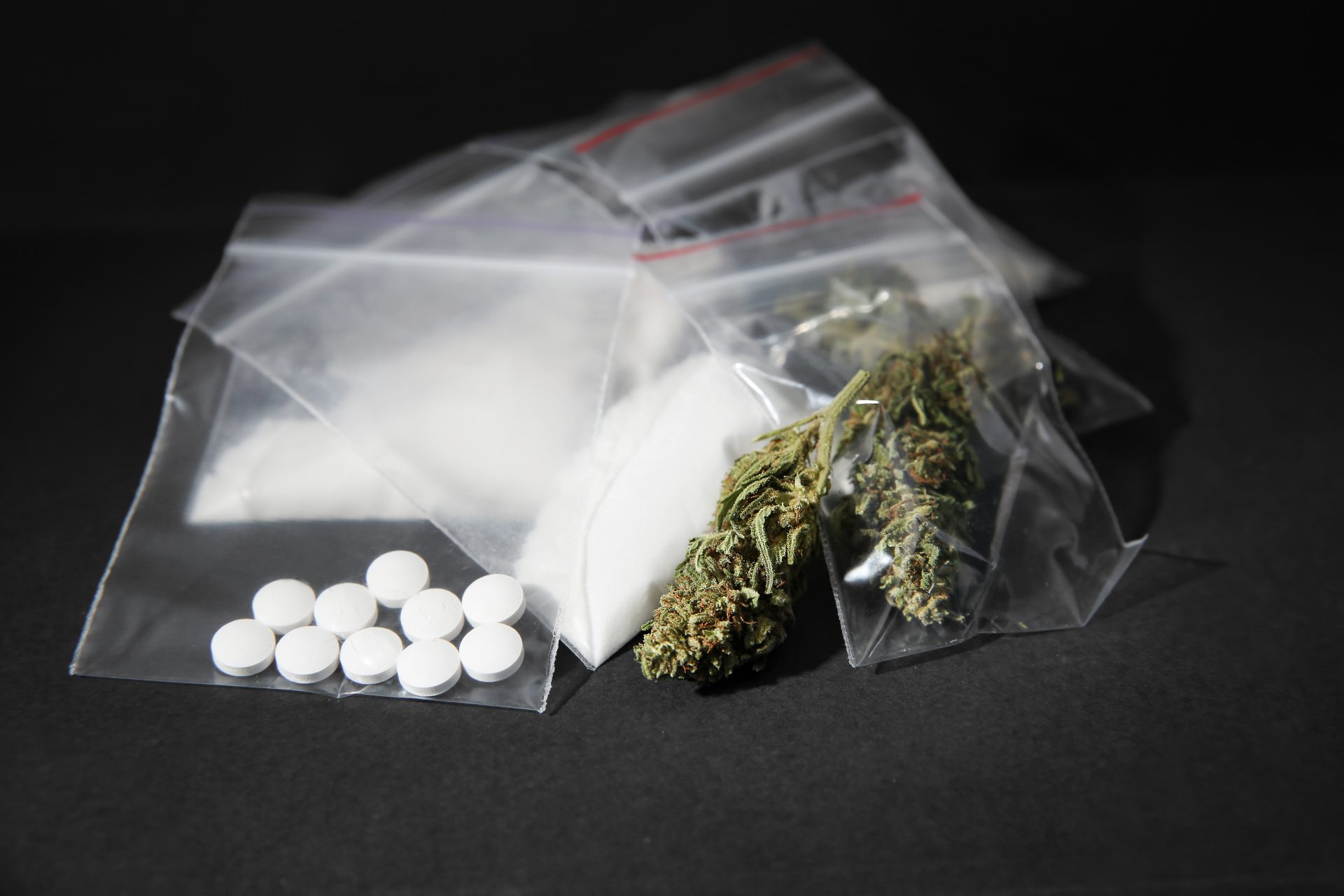 Cocaine, dried hemp and ecstasy on grey table Betäubungsmittel
